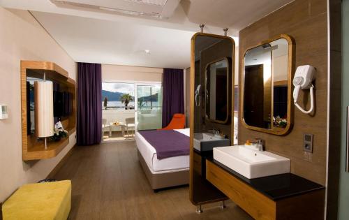 马尔马里斯Casa De Maris Spa & Resort Hotel Adult Only 16 Plus的一间带水槽、床和镜子的浴室