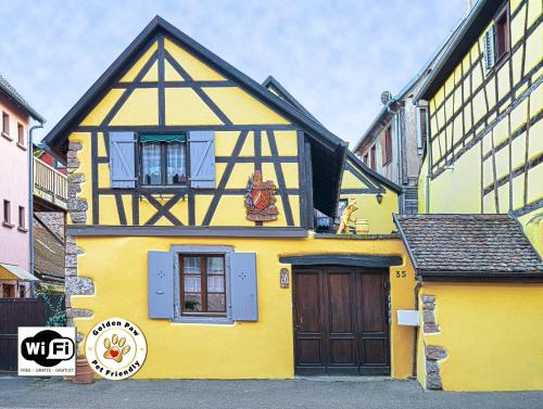 希伯维列Gîtes de la Maison Vigneronne, au Coeur de Ribeauvillé的黄色的黑色和黄色房子