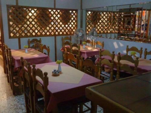 阿齐亚·佩拉加·基西拉凯瑟莱亚酒店的餐厅配有桌椅和紫色的桌布
