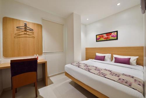 孟买Hotel Leafio-Near Airport的配有一张床和一张书桌的酒店客房
