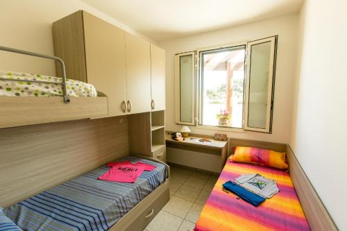 托雷苏达Complesso Gardencasa的小房间设有两张床和窗户