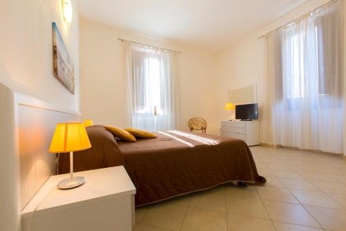 特拉帕尼芭芭拉度假屋的一间卧室配有一张床和一张带台灯的桌子