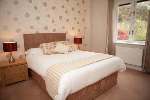 卡斯尔敦贝尔Berehaven Lodge的一间卧室设有一张大床和一个窗户。