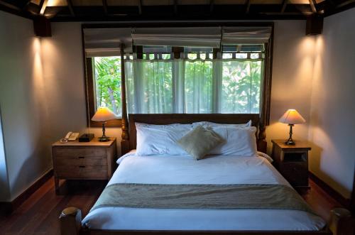 库塔德斯里温长廊别墅酒店的一间卧室配有一张带窗户和两盏灯的床。