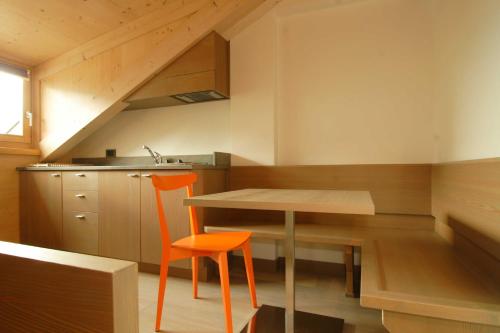 瓦莱迪卡多雷Dolomiti Lodge Villa Gaia的一个带桌子和橙色椅子的小厨房