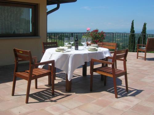 蒙泰斯佩尔托利Podere Ghiole的庭院里配有带白色桌布和椅子的桌子