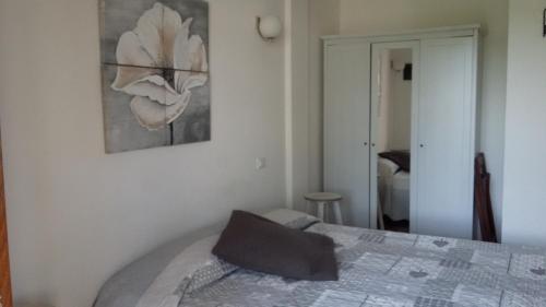 萨尔扎纳训马场酒店的卧室配有一张床,墙上挂有绘画作品