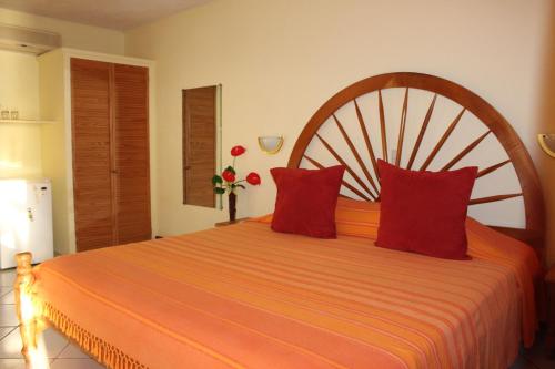 Salisbury塔玛林德树酒店的一间卧室配有带红色枕头的大型橙色床