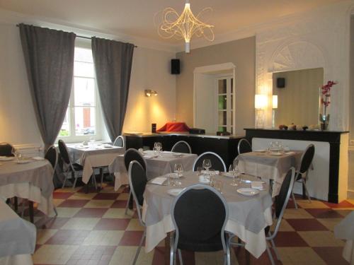 图兰的圣莫尔白马之家酒店的餐厅配有白色的桌椅和吊灯