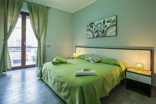 庞贝生态住宿加早餐酒店的一间卧室配有一张带绿床罩的床