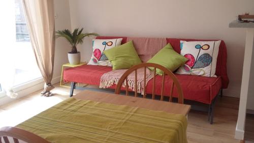 洛涅芦苇丛中公寓的客厅配有红色沙发及色彩缤纷的枕头