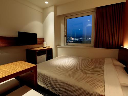 大洲大津熊本机场光芒酒店的一间卧室设有一张床和一个美景窗户。