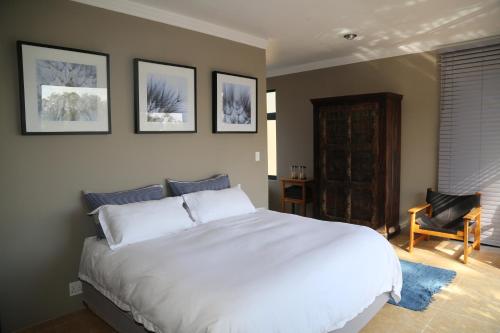 鲁德普特Natures Haven的卧室配有一张白色大床和一把椅子