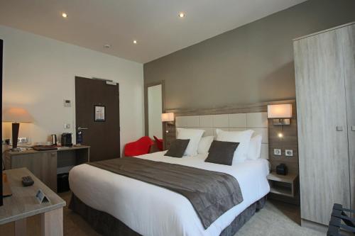 普瓦西鲟鱼酒店的酒店客房设有一张大床和一张书桌。