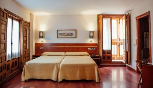 托莱多圣伊萨贝尔酒店的一间卧室,卧室内配有一张大床