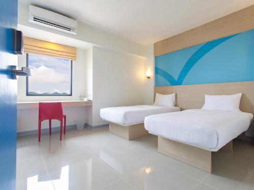普吉镇Hop Inn Phuket - SHA Plus的酒店客房,设有两张床和一张红色椅子