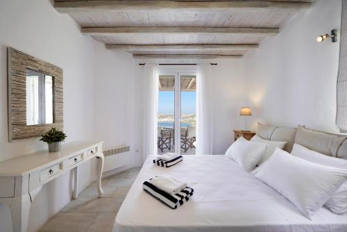 奥诺斯Nalu Villa的白色的卧室设有一张白色大床和一个窗户。