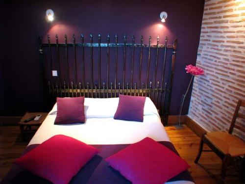 吕齐古宅酒店的一间卧室配有一张带红色和紫色枕头的床