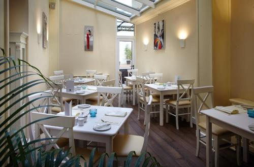 利沃夫Rudolfo Hotel的一间餐厅,房间内设有白色的桌椅