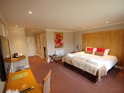 奥尔斯特国王法庭酒店的一间卧室配有一张带红色枕头的大床