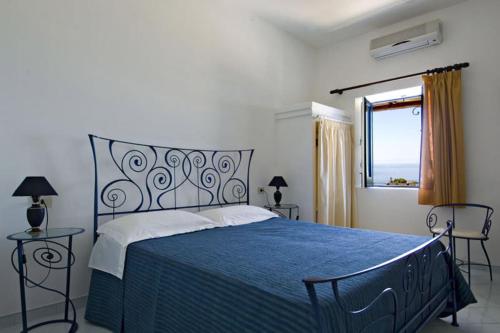 帕纳雷阿Hotel Girasole的一间卧室设有蓝色的床和窗户。