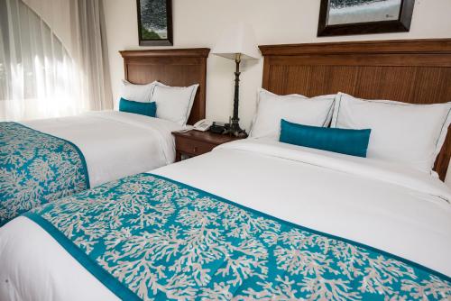 雅科蓬塔利昂娜酒店的酒店客房带两张带蓝白床单的床。