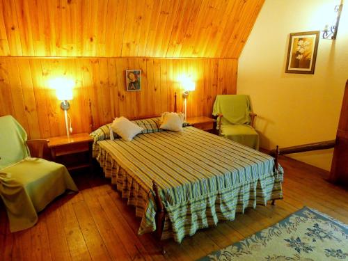 波特雷里约斯La Casa del Tata的一间卧室配有一张床和两张绿色椅子