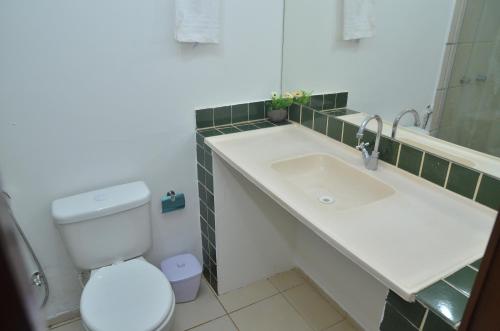 阿奎拉兹Hotel Pousada Summer Way的一间带水槽、卫生间和镜子的浴室
