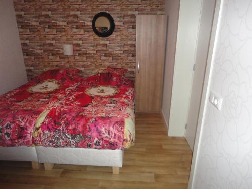 巴讷费尔德德好伊博格住宿加早餐旅馆的一间卧室设有红色的床和砖墙