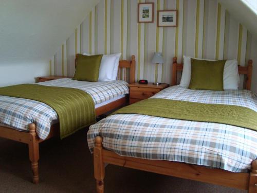 斯佩河畔格兰敦柳岸酒店的两张睡床彼此相邻,位于一个房间里