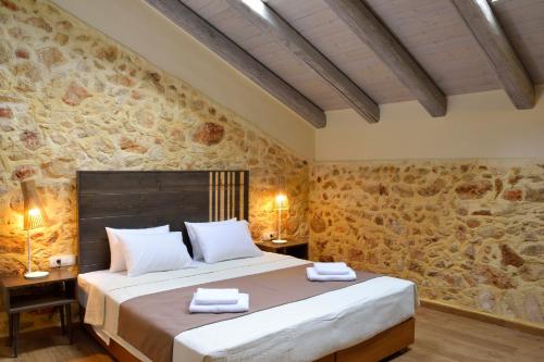 干尼亚Elia Kentron的一间卧室设有一张大床和石墙