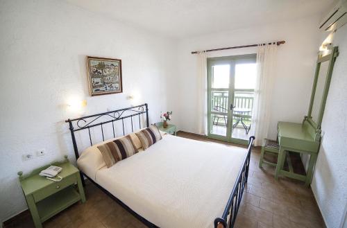 伊斯特隆Elpida Village的一间卧室设有一张大床和一个窗户。
