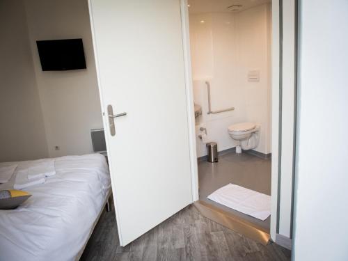 VervinsLogis Hotel Restaurant Le Relais Fleuri的一间卧室配有一张床,浴室设有卫生间
