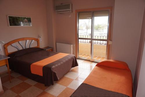 塞维利亚阿拉玛雷酒店的一间卧室设有一张床和一个阳台的窗户。