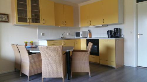 东弗利兰de Zanding的厨房配有黄色橱柜和桌椅