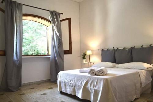 梅林La Frantoiana的一间卧室配有一张床,上面有两条毛巾