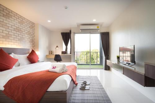 曼谷Q空间酒店的一间卧室设有一张大床和一个大窗户