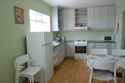 格仑达积图格伦达菲厄泽旅舍的厨房配有白色橱柜和桌椅