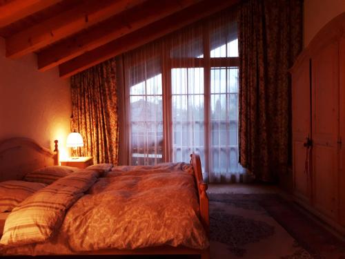 上罗伊特Haus Erika的一间卧室设有一张床和一个大窗户