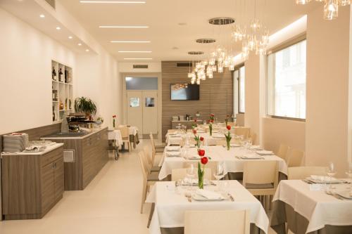 玛格丽塔萨沃亚瑞纳里餐厅酒店的用餐室配有白色的桌子和白色的椅子