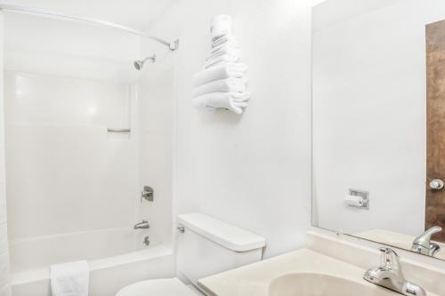 Montgomery速8蒙哥马利酒店的一间带卫生间、水槽和镜子的浴室