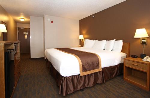 林垦林肯新维多利亚套房酒店的酒店客房带一张大床,带白色床单