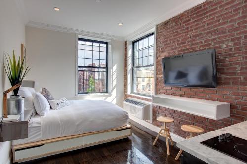 纽约东乡村酒店的一间卧室设有一张床和砖墙