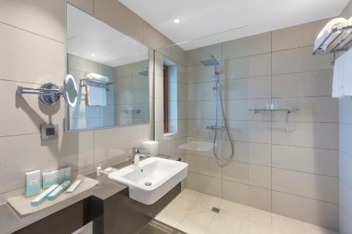 维拉港Ramada Resort by Wyndham Port Vila的白色的浴室设有水槽和淋浴。