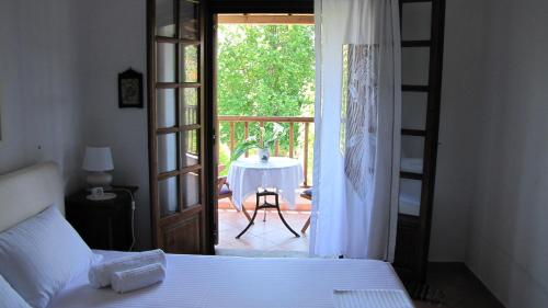 寇特EL Villa Pelion的一间卧室设有一张床,一扇门通往庭院