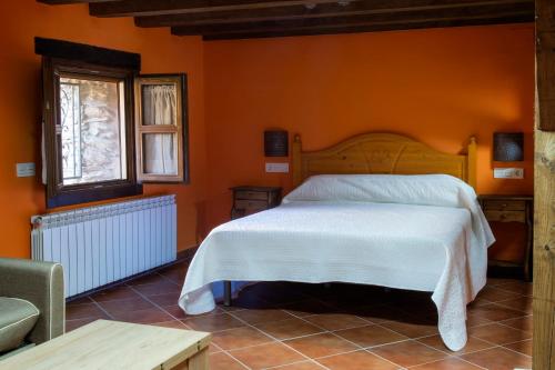 罗夫莱迪略德加塔Molino del Medio的一间卧室配有一张橙色墙壁的床