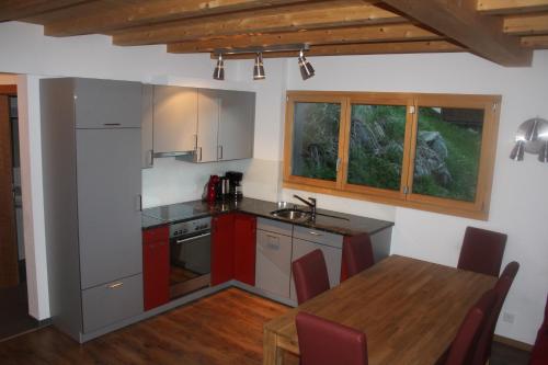 贝特默阿尔卑瓦卡蒂普旅舍的厨房配有红色橱柜和木桌