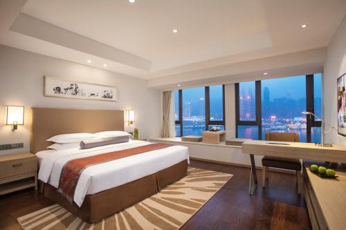 重庆重庆盛捷长江服务公寓的一间卧室配有一张大床、书桌和窗户