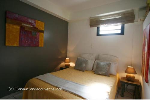 厄唐萨雷La Buddha Case的卧室配有一张床,墙上挂有绘画作品