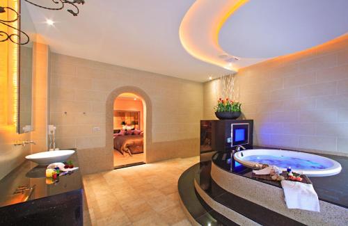 竹山丽堡休闲精品汽车旅馆的带浴缸的大浴室和卧室